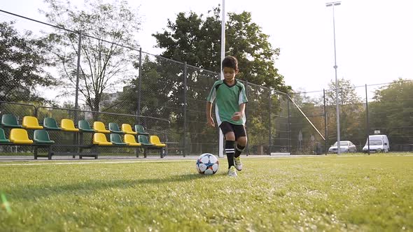 Young Football Player Making Trick with the Soccer Ball