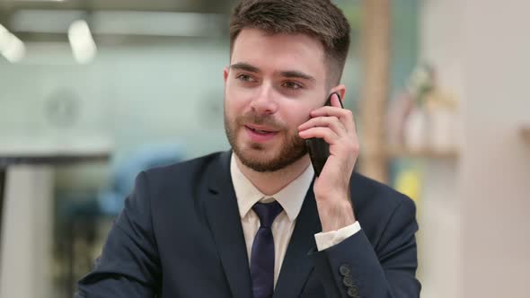 Cheerful Young Businessman Talking on Smartphone