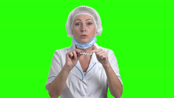 Caucasian Doctor Showing Pills on Green Screen.