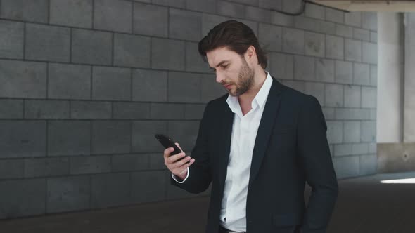 Business Man Typing on Smartphone at Street. Excitement Guy Celebrating Success