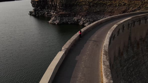 Aerial of a woman hiking across the Salmon Falls Dam in Southern Idaho