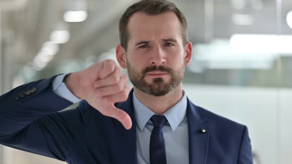 Portrait of Disappointed Businessman Doing Thumbs Down 