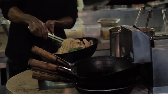 Chinesse Chief Cook Cooking on the Wok Pan with Flambe on the Asian Restaurant Kitchen Pasta Seafood