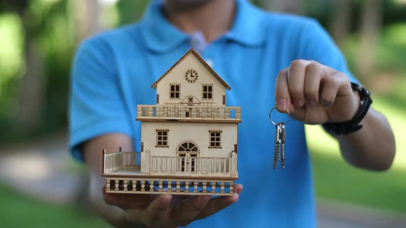 Man Holding House Model And Keys