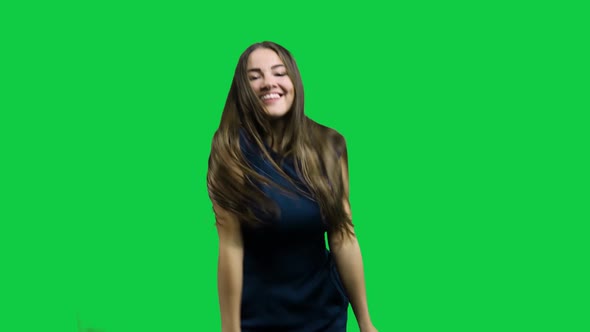 Happy girl dancing in front of the green screen