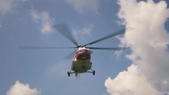 Emergency Service Helicopter Flying Against Clouds alt