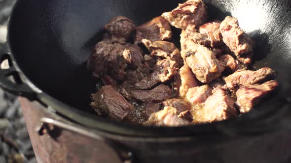 Meat for Uzbek Pilaf is Stewed Over the Fire in a Cauldron