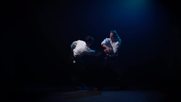 Two Fighters Participants of the Training in Special Clothes of Aikido Hakama Work Out the Methods