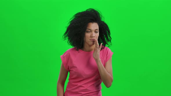 Portrait of Young Female African American Covering Her Mouth with Her Hand and Whispering the Secret