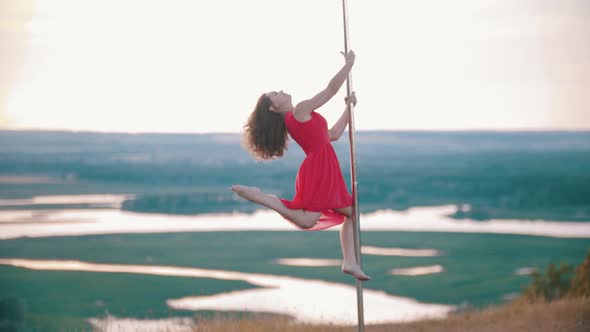 Young Woman in Pink Dress Dancing on the Pole