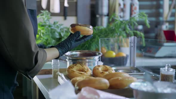 Delicious Fried Donut Dipped in Chocolate and Sprinkled with Sweet Powder in Kitchen of Restaurant