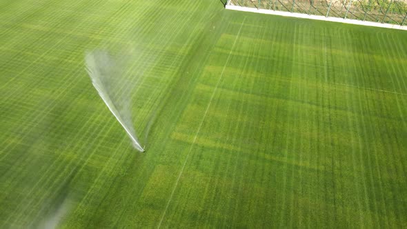 Aerial View on Top Automatic Watering of the Stadium and Green Grass. Irrigation of Green Grass