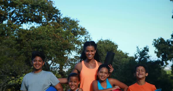 Portrait of instructor standing with exercise mat