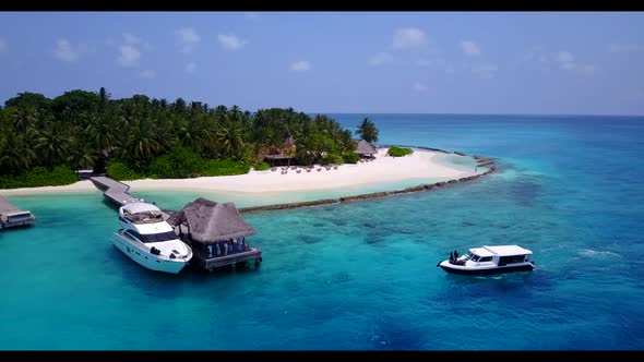 Aerial drone view seascape of relaxing tourist beach vacation by blue lagoon with white sand backgro