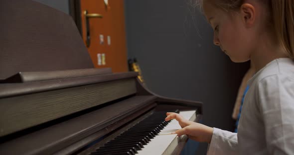 Little Girl Playing Piano at Home. Kid Play Piano in Living Room. Child Learning Piano at Home