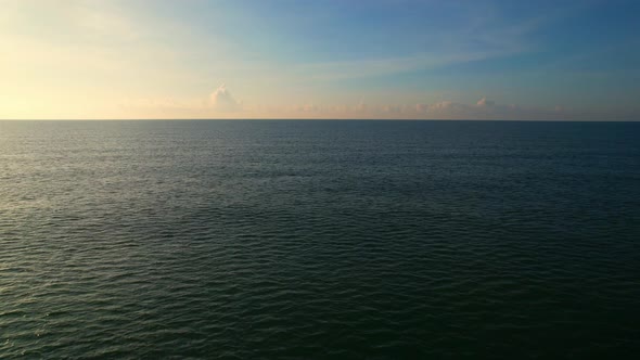 Aerial view from a drone, waves in the orange sea Sunset