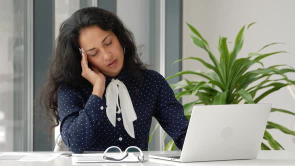 Stressed young mixed race woman in glasses suffering from headache