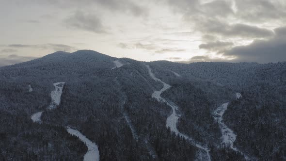 Snow frosted peak of an abandoned ski mountain at sunset AERIAL