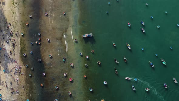 Aerial top down, Vietnamese round coracle fishing boats floating on beach shore