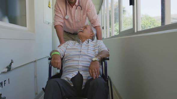 Doctor walking a senior man in a corridor of the retirement home