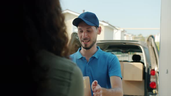 Delivery Guy Giving Cardboard Box to Female Client Using Smart Phone Talking Smiling