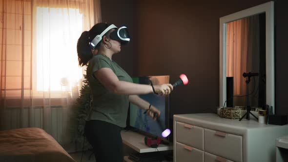 Woman is wearing augmented reality headset, playing games, drawing abstract lines, using joysticks