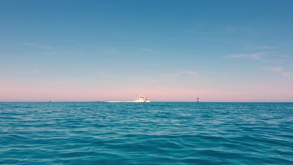 Sailing towards motor boat in open blue sea