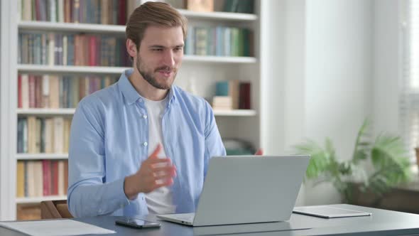 Man Talking on Video Call on Laptop in Office