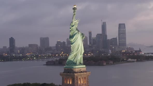 AERIAL: Circling Statue of Liberty Beautifully Illuminated in Early Morning Light New York City 