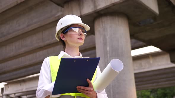 Young Female Builder in a Hard Hat at a Construction Site