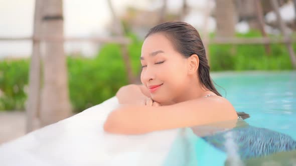 Young asian woman enjoy around outdoor swimming pool for leisure