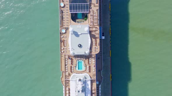 Aerial top-down forward over luxury cruise ship moored in port of Taino bay, Puerto Plata in Dominic