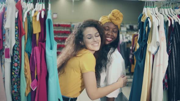 Two Lovely Ladies Are Smiling and Hugging in the Shop