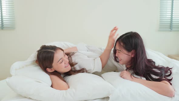 Asian beautiful lesbian couple wake up from sleep in bedroom in morning.