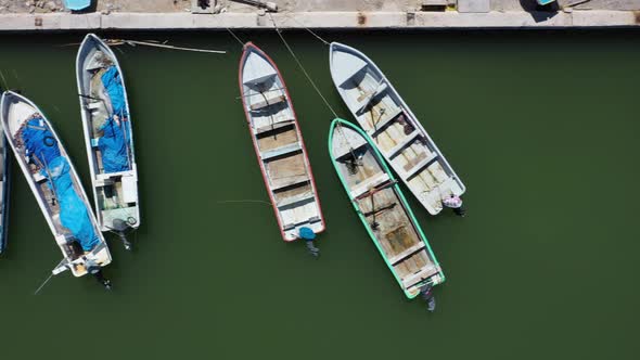 Aerial view looking straight down and camera sliding to the right showing small wooden fishing boats