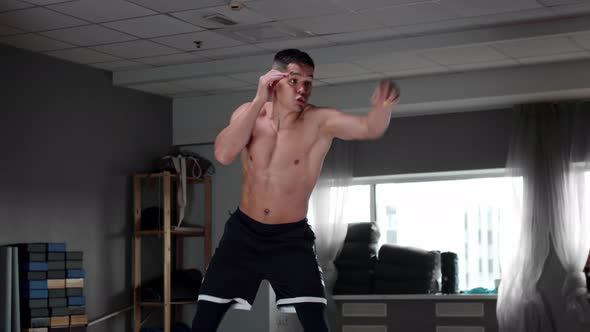 Young Pumped Up Man in the Gym Training His Agility  Bounces a Small Ball Off the Floor