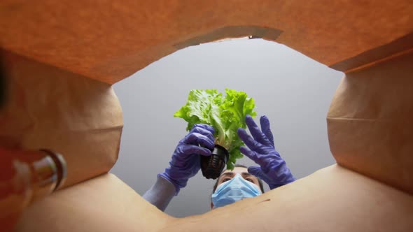 Woman in Gloves and Mask with Food in Paper Bag