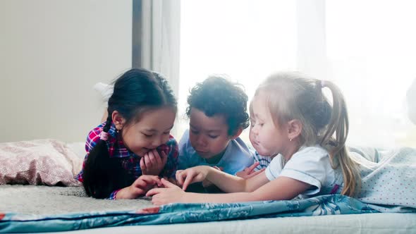 Group of Little Multiethnic Friends Typing on Tablet