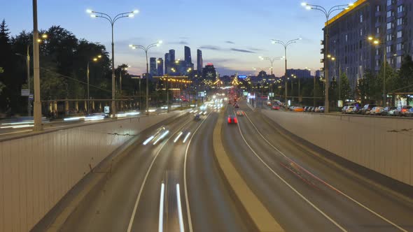 Cars Silhouettes Drive Against Flashing Skyscrapers