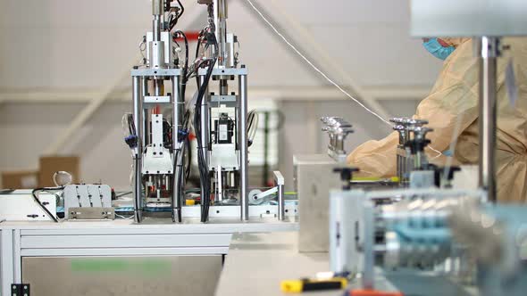 Production of Medical Masks - The Machine Produces Medical Masks and Staff Worker Monitors the