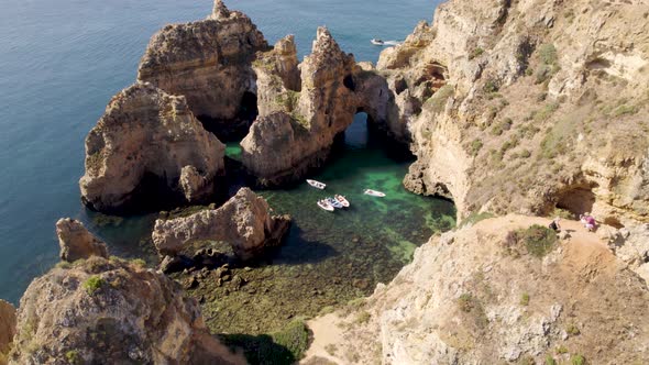 Small fishing boats sheltered between Algarve cliffs in Lagos - Aerial