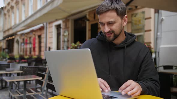 Bearded Man Working Remotely Outdoors with Laptop