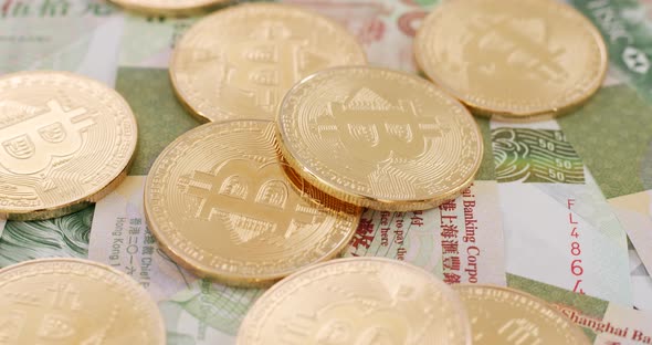 Bitcoin and Hong Kong banknote in spinning
