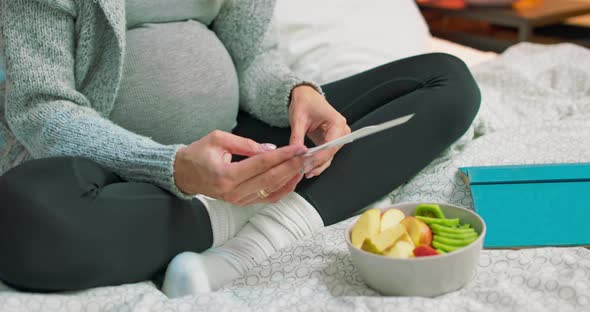 Pregnant Woman Sitting on Bed Watching Pregnancy Ultrasound Prints