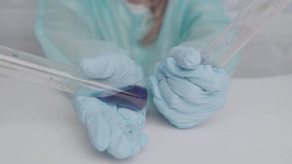 Doctor in protective gloves holds laboratory test tubes with liquid