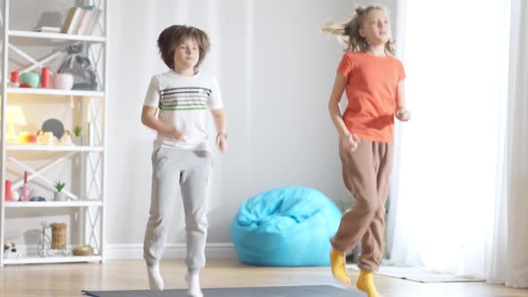Fit Caucasian Boy and Girl Running in Place at Home