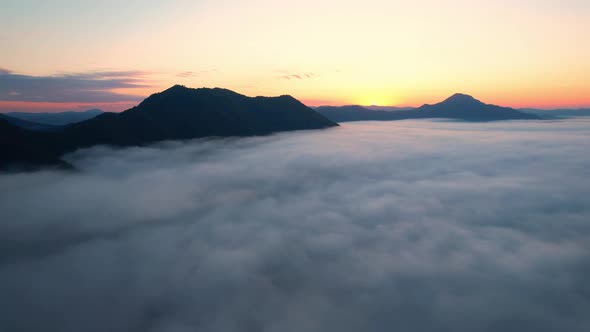 4K Aerial video Beautiful sunrise above dense clouds and fog in the morning, Cinematic drone shot.