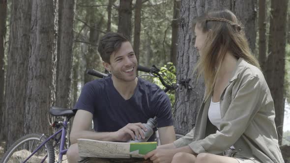 Young couple looking at map in woods