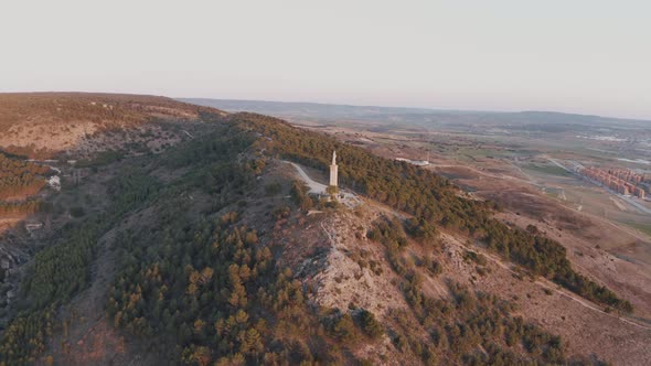 Drone view of statue of Jesus on a hill in Cuenca, Spain