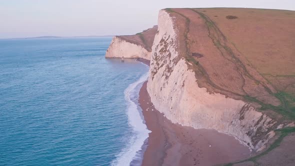 White chalk cliffs at Durdle Door at sunrise, Lulworth Cove, Dorset, England, UK. Aerial drone view